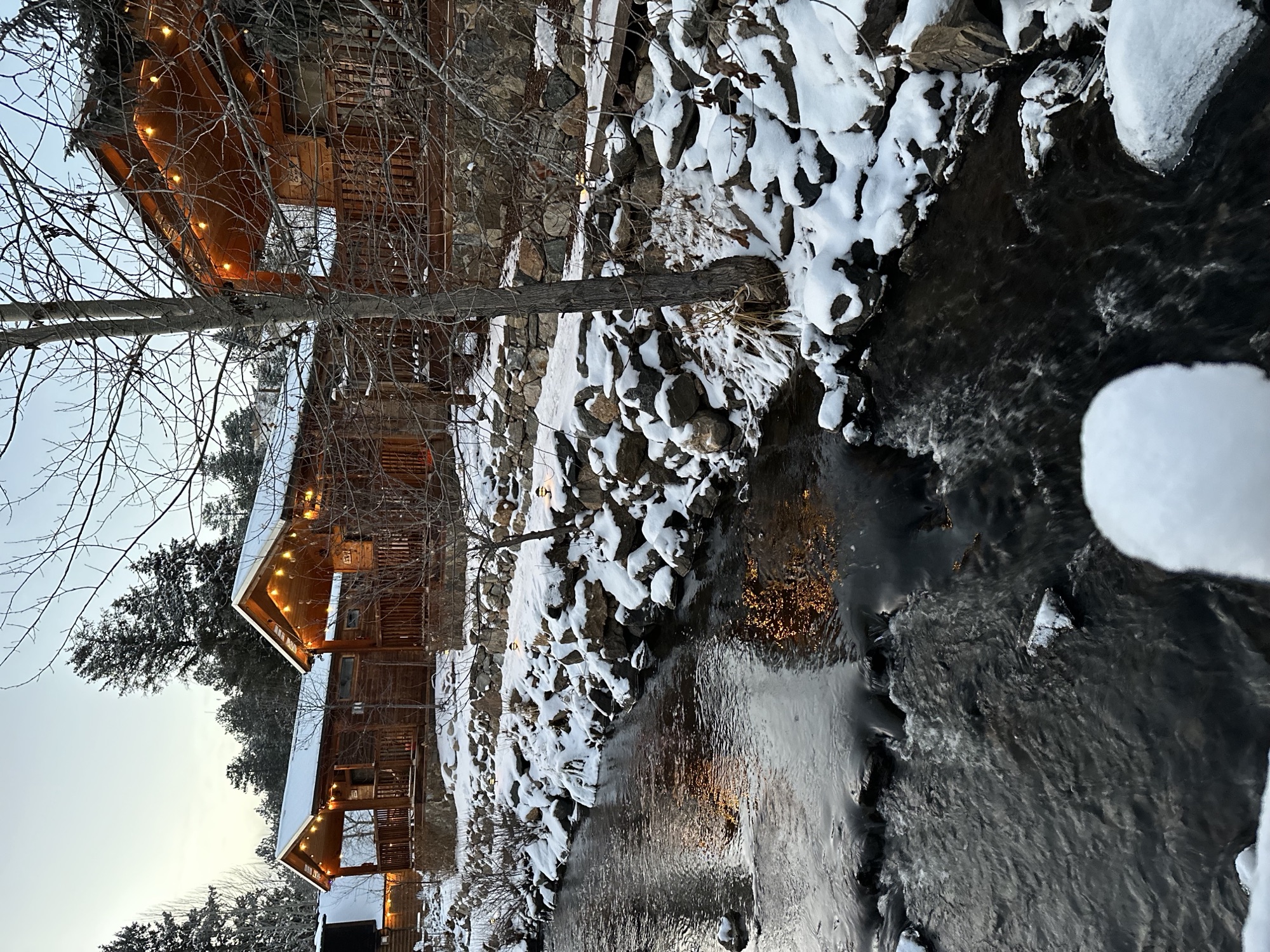 Winter creek with cabin lights